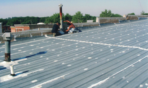 A shot of the workers applying roofing tape to the chimney boot.